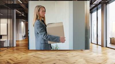 Happy woman with cardboard box coming out from elevator Wall mural