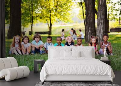 A large group of preschool children playing in the Park on the grass. The concept of friendship, childhood.Children's day, June 1 Wall mural