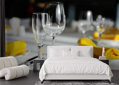 beautiful empty wine glasses and yellow napkin on a decorated table close-up. Wall mural