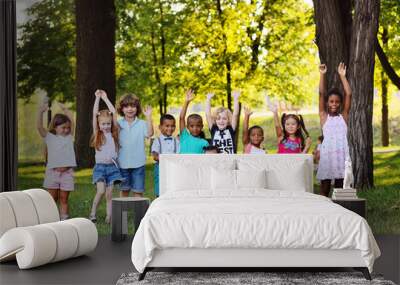 many young children of different races play together in the Park on the green fresh grass. The concept of ethnic friendship of different peoples. Wall mural