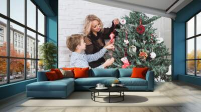 Mother and her son are at home decorated for Christmas. Family miracle time. Merry Christmas and Happy New Year. Wall mural