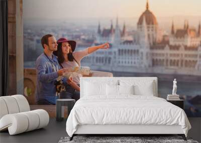 Young couple searching right direction on map from the point from Fisherman Bastion in Budapest with Hungarian Parliament building on background Wall mural