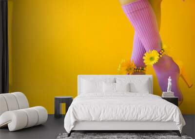 Women's feet in purple socks with flowers and shoes on a yellow background Wall mural