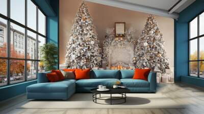 Hall room interior with a fireplace with candles and two decorated Christmas trees with gifts. Large designer snow tree with lights and balls in beige, brown, gold and silver colors. Wall mural