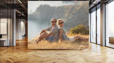 Romantic couple have a date at the top of the mountains with ocean view Wall mural