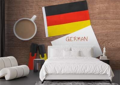 german national flag, notebook with the inscription german language school, two markers, cup of coffee on brown wooden desktop, study concept Wall mural