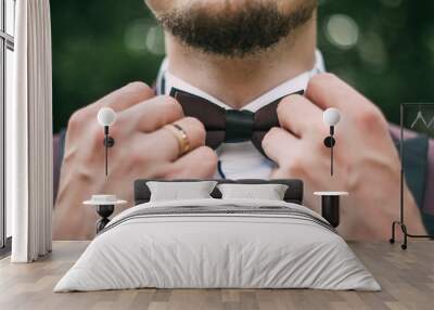 the groom is preparing for the wedding, holding hands on a butterfly on the neck 1 Wall mural