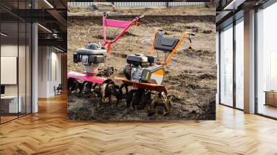 Two options for a plow cultivator on arable land. Plows the ground with a tillerblock in the garden. The land with a cultivator preparing the soil for sowing Wall mural