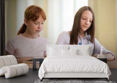 2 student girls are sitting at a Desk Wall mural