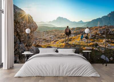 two young man enjoying the view of the mountains landscape in the dolomites national park, south tyrol Wall mural