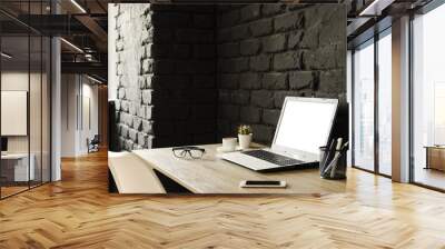 Creative workspace of a blogger. White laptop computer & folded eye glasses on wooden table in loft style office with black brick walls. Designer's table concept. Close up, copy space, background. Wall mural