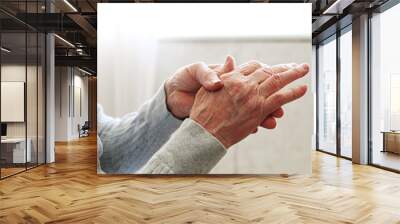 Elderly woman applying moisturizing lotion cream on hand palm, easing aches. Senior old lady experiencing severe arthritis rheumatics pains, massaging, warming up arm. Close up, copy space, background Wall mural