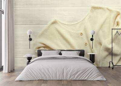 Fashionable easy chic casual style oversized sweater with buttons on white wood textured table background. Top view, close up, copy space. Stylish women's knitwear clothing lying on wooden surface. Wall mural