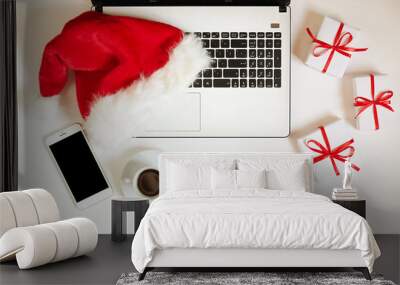 Laptop and santa hat on it with christmas gifts on white background top view with copy space. Business christmas holidays concept, online holidays shopping concept flat lay Wall mural