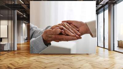 Mature female in elderly care facility gets help from hospital personnel nurse. Cropped shot of senior woman's hands with aged wrinkled skin and care giver. Background, copy space, close up. Wall mural