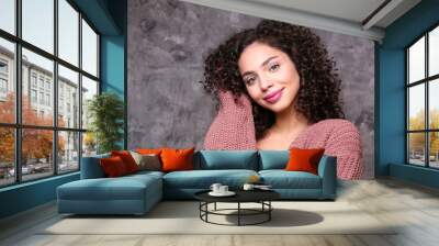 Portrait of happy beautiful woman with long bouncy curles hairstyle and professional make up on, posing over grunged stone background. Fashion shot of young gorgeous female. Close up, copy space. Wall mural