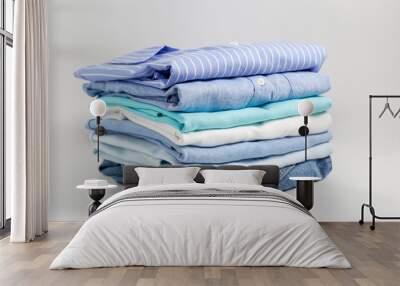 Stack of colorful perfectly folded clothing items. Pile of different pastel color shirts, sweaters isolated and other garments on white background. Close up, copy space. Wall mural