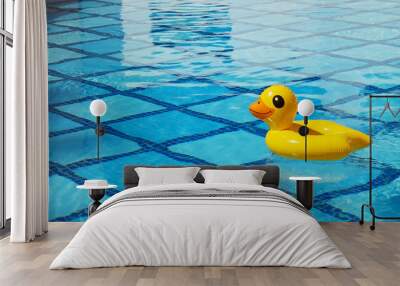 Top view of inflatable duck floating in an empty swimming pool with crystal clear water and blue square tile pattern background. Close up shot of rubber ring with a lot of copy space for text. Wall mural