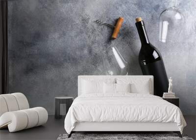 Vintage bottle of red wine with blank matte black label, corkscrew on grunged concrete table background. Expensive bottle of cabernet sauvignon concept. Copy space, top view, flat lay. Wall mural