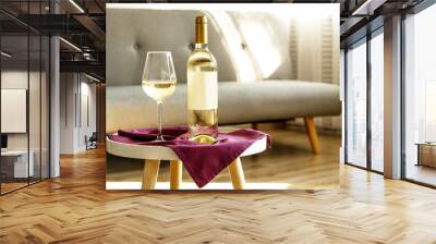 vintage bottle of white wine with blank matte label and poured glass on purple napkin, lofty interio Wall mural