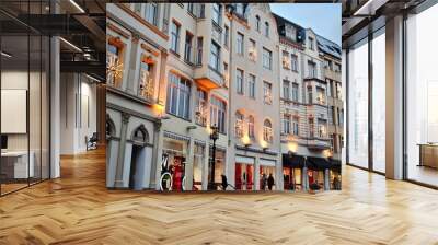 Row of white European storefronts on Martinsplatz Street decorated for Christmas sales with holiday shoppers.  Wall mural