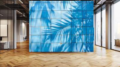 A serene scene of a vibrant blue tiled wall contrasted with lush palm leaves, creating a tropical oasis ambiance Wall mural