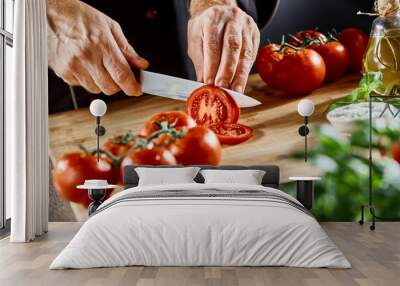 Close up on man slicing up small tomatoes Wall mural