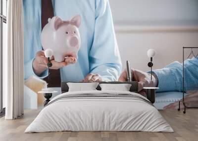 Man Holding Pig Bank in Business Meeting Wall mural