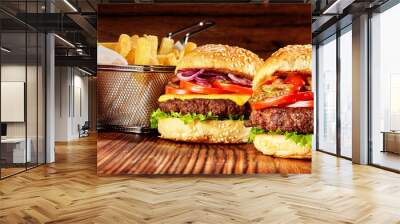 two tasty burgers with basket of fries and sauce Wall mural