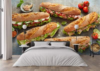 Various sub sandwiches and ingredients on table Wall mural