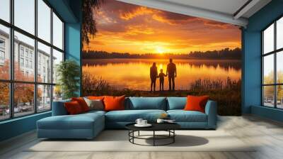 A family of four standing together at the edge of a calm lake, holding hands as they watch the golden sunset, with warm reflections on the water Wall mural