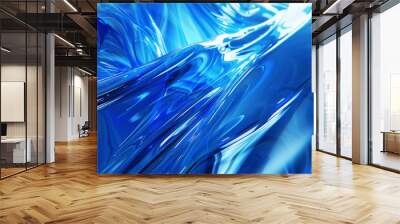 A blue, shiny, and reflective surface with a wave-like pattern Wall mural