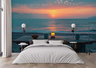 A table with a candle and two cups on it, with the sun setting in the background Wall mural