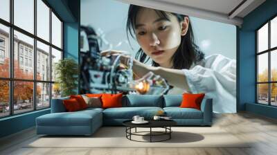 a young asian woman, adjusting robotics components, technical and curious, with a plain white backdr Wall mural