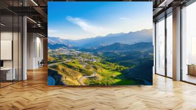 Aerial a mountainous region with winding roads and small villages nestled in the valleys, highlighting the rugged beauty of the terrain Wall mural