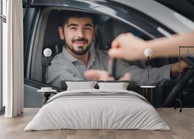 Happy Young man receiving car key from saleswoman, sitting inside modern automobile, woman gave the keys to the customer purchase contract and key delivery. Successful completion of car sales, rental Wall mural