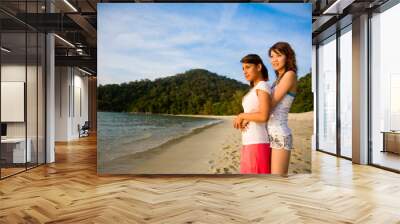 two girls hugging by the beach looking at sunset Wall mural