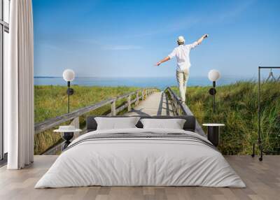 Young man enjoying his freedom near the beach Wall mural