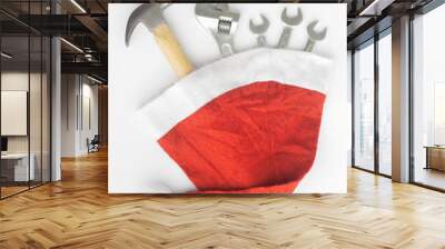 Hammer, adjustable wrench, wrenches in Santa Hat. Handy tools in Christmas festival background concept. Wall mural