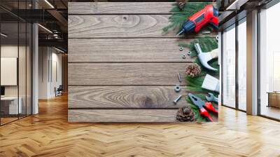 Merry Christmas and Happy new year handy construction tools background concept. Hammer, wrenches, screwdriver, pliers, paint brush, pine leaves, pine cones decoration on  wood background.  Wall mural