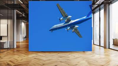 wide-body plane is flying in blue sky Wall mural