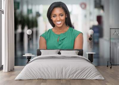 African American woman in green dress in modern corporate building lobby Wall mural