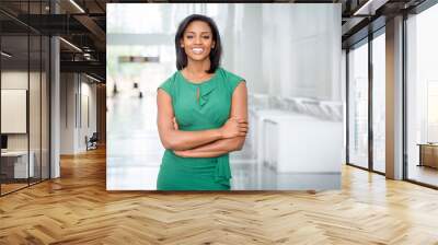 African American woman in green dress in modern corporate building lobby Wall mural