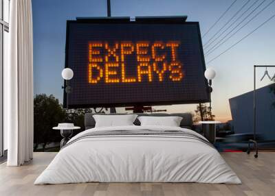 Electrionic traffic sign stating Expect Delays with blurred traffic at sunset Wall mural