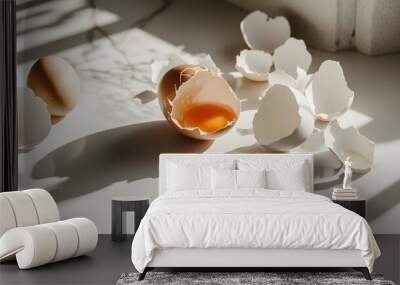 Cracked egg with yolk spilling out surrounded by empty eggshells, symbolizing food safety recall on clean white surface Wall mural