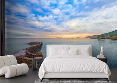 Beautiful colorful sunrise at the calmness sea shore with cloudy sky Wall mural