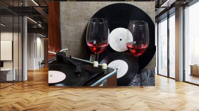 Old turntable. Nearby are two glasses of alcohol. Retro party equipment. Wall mural