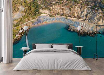 Aerial bird's eye view of Konnos beach in Cavo Greco Protaras, Paralimni, Famagusta, Cyprus. The famous tourist attraction golden sandy Konos bay, yachts, on summer holidays, at sunrise from above Wall mural