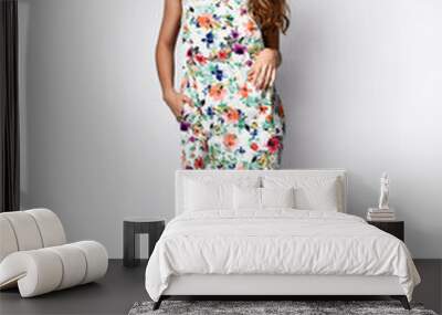 Luxurious young slim girl with long hair in a long dress with a floral print and a straw hat. Getting ready is going on a date on a warm summer evening. Wall mural