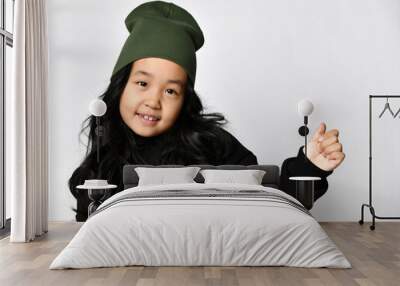 young attractive Asian teenage girl, 10 years old, wearing warm autumn or spring black sportswear and a dark green hat, posing for the camera Wall mural